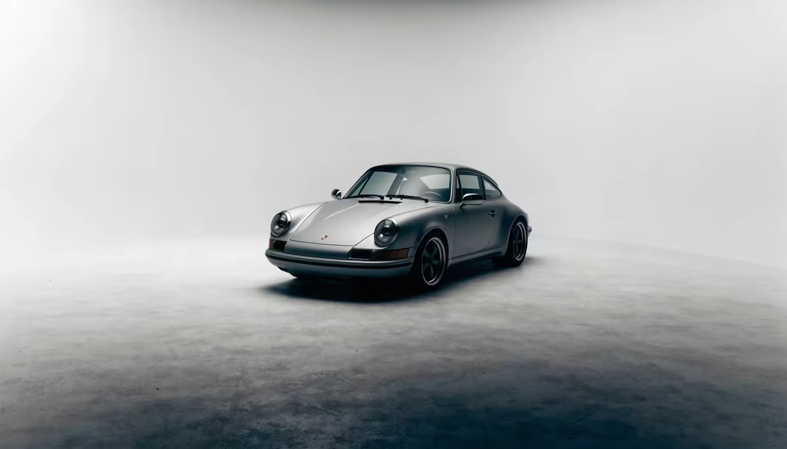 Silver Porsche 911 in a grey studio, front three-quarter view