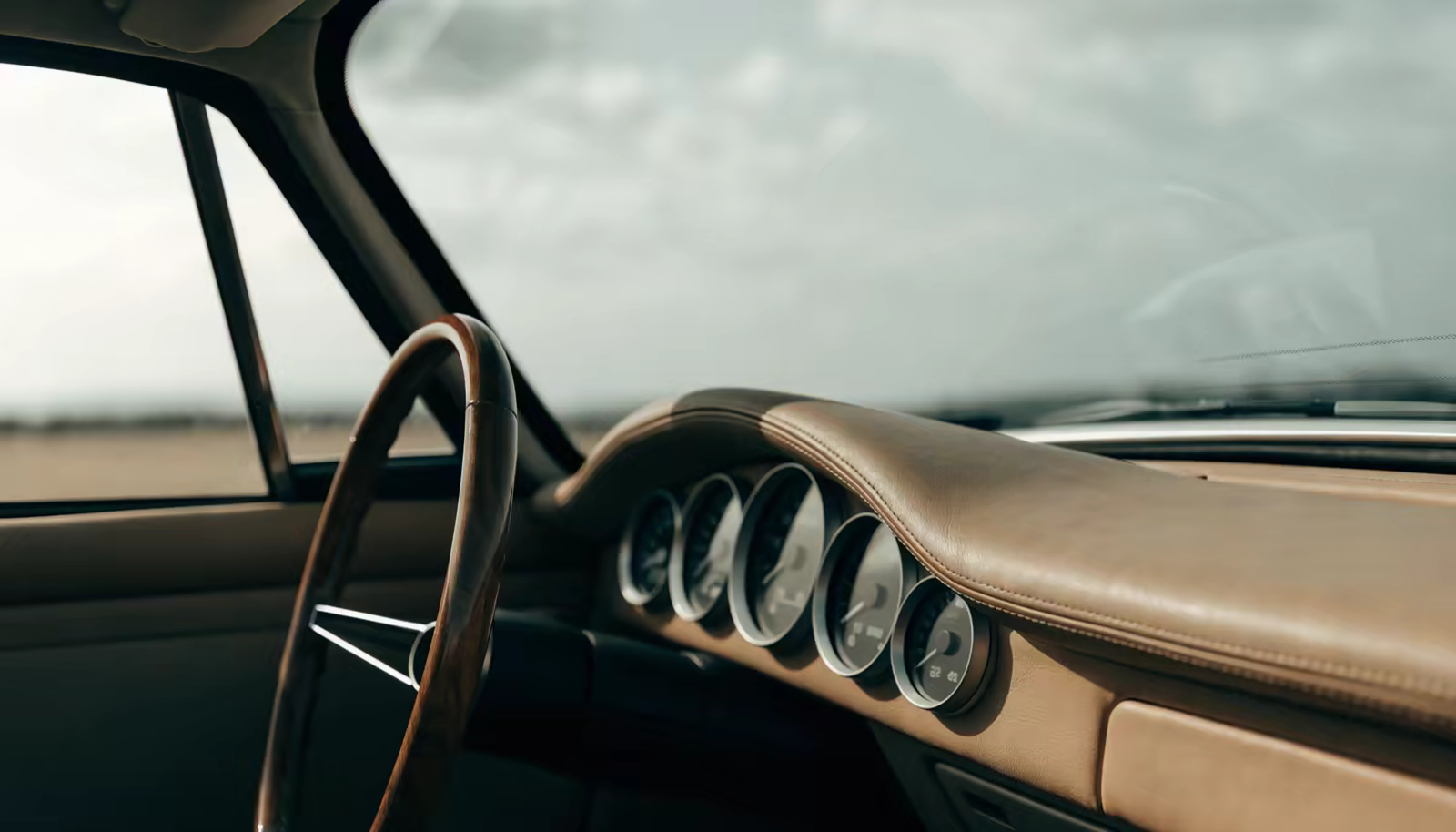 Porsche 911 cabin with wooden steering wheel and five round gauges